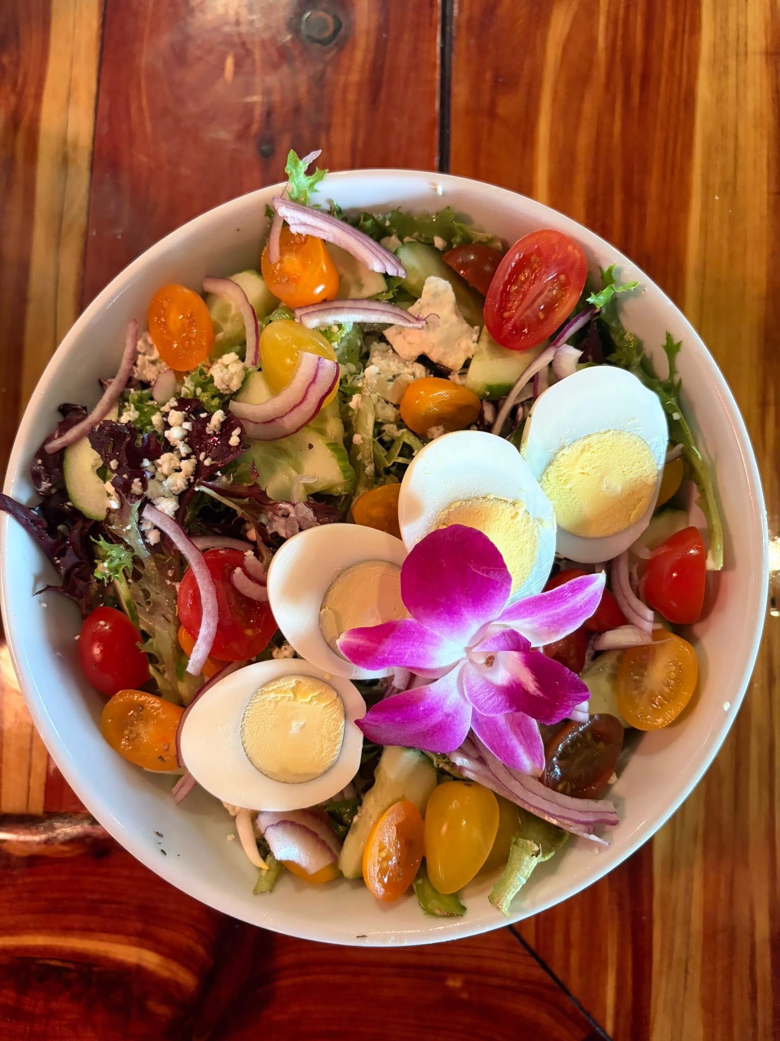 Colorful chef salad with eggs, tomatoes, cucumber, and greens